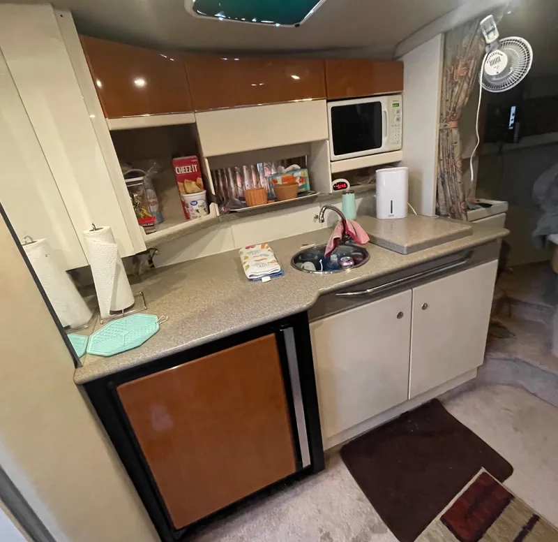 Slide: The Image of 1999 Formula 34 PC boat kitchen with sink, microwave, and storage cabinets. - 22