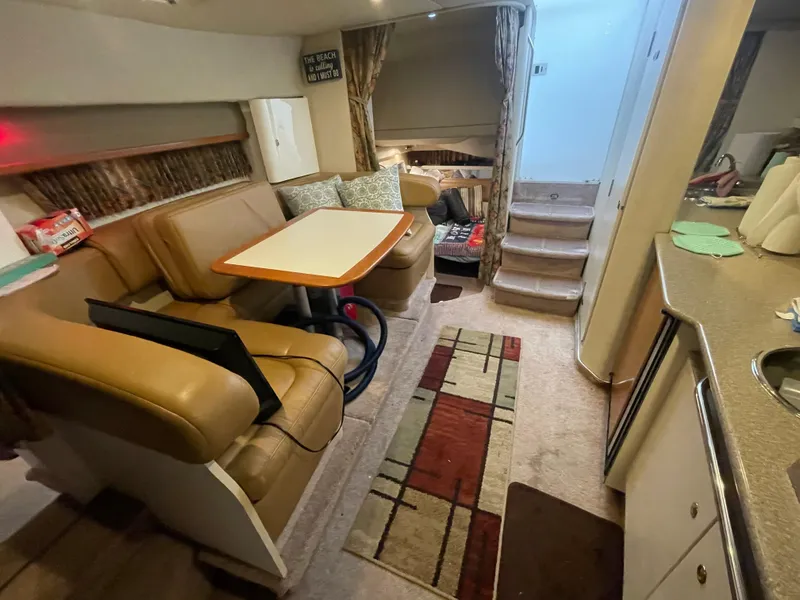 Slide: The Image of 1999 Formula 34 PC yacht interior with dining area, stairs, and kitchenette. - 23