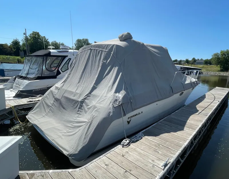 Slide: The Image of 1999 Formula 34 PC boat covered at dock under clear blue sky. - 28