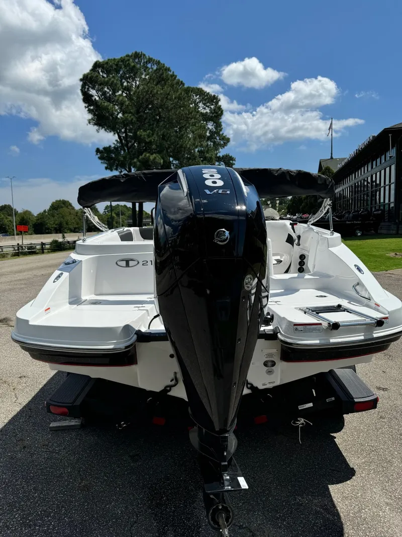 Slide: The Image of 2024 Tahoe 2150 boat with outboard motor, parked outdoors under a clear sky. - 3