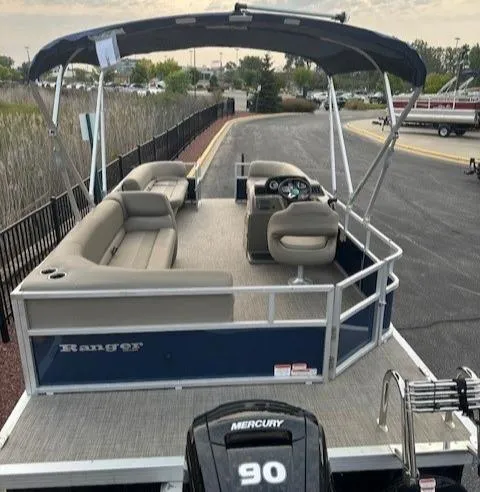 Slide: The Image of 2024 Ranger Reata 200C pontoon boat with canopy and Mercury 90 engine. - 2