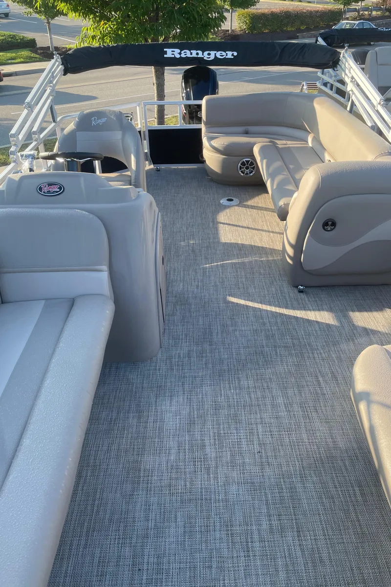 Slide: The Image of 2024 Ranger Reata 200C pontoon boat interior with plush seating and modern design. - 2