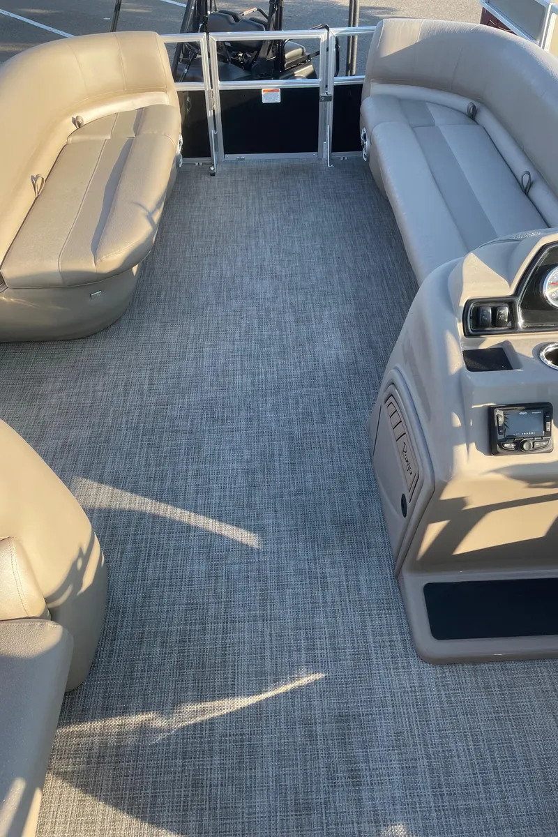 Slide: The Image of 2024 Ranger Reata 200C boat interior with gray carpet and beige seating. - 3