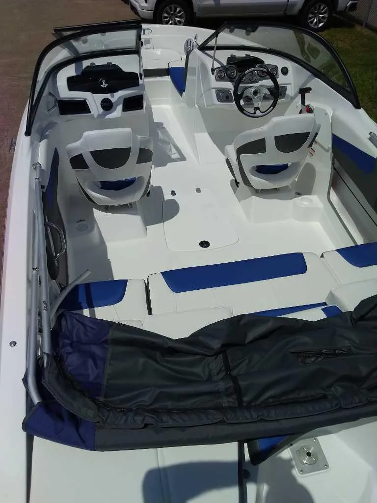 Slide: The Image of 2024 Tahoe 200 S boat interior with white and blue seating, steering wheel, and dashboard. - 6
