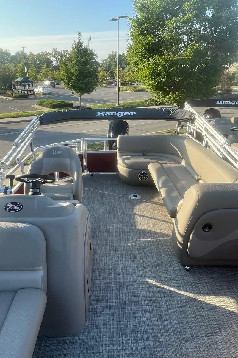 Slide: The Image of 2024 Ranger Reata 200C pontoon boat with plush seating and steering console. - 3