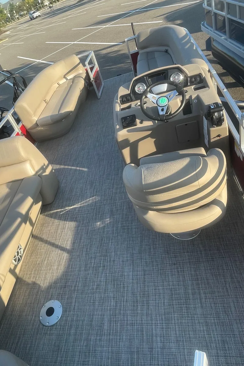 Slide: The Image of 2024 Ranger Reata 200C boat interior with beige seating and steering console. - 4