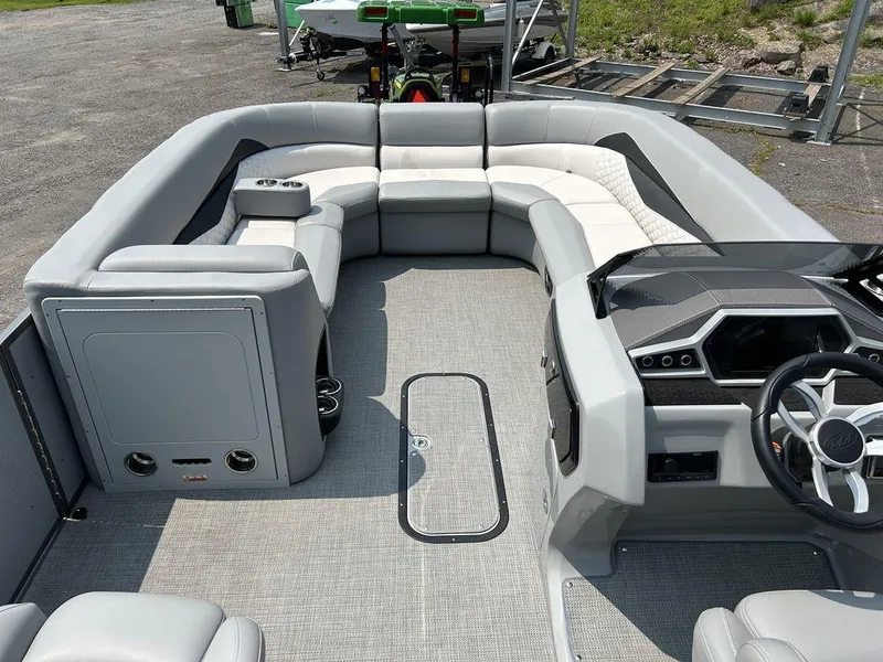 Slide: The Image of 2022 Manitou Encore 25 pontoon boat interior with modern seating and steering console. - 14