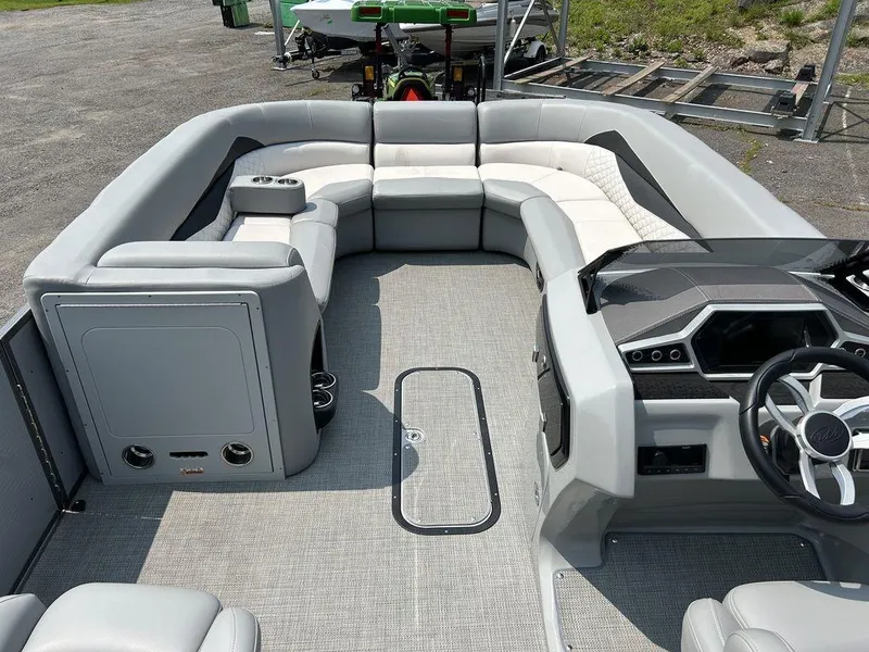 Slide: The Image of 2022 Manitou Encore 25 pontoon boat interior with modern seating and steering console. - 8
