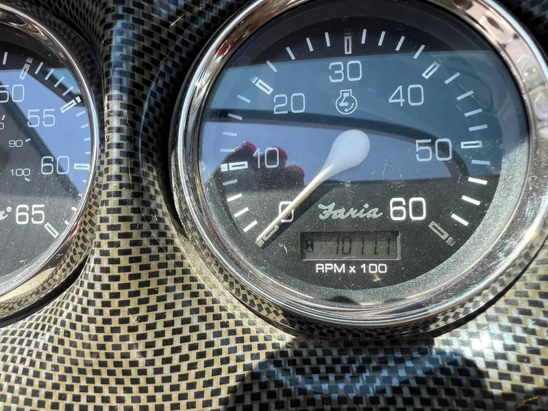 Slide: The Image of Close-up of a 2001 Crownline 192 BR boat tachometer, showing RPM gauge and carbon fiber texture. - 10