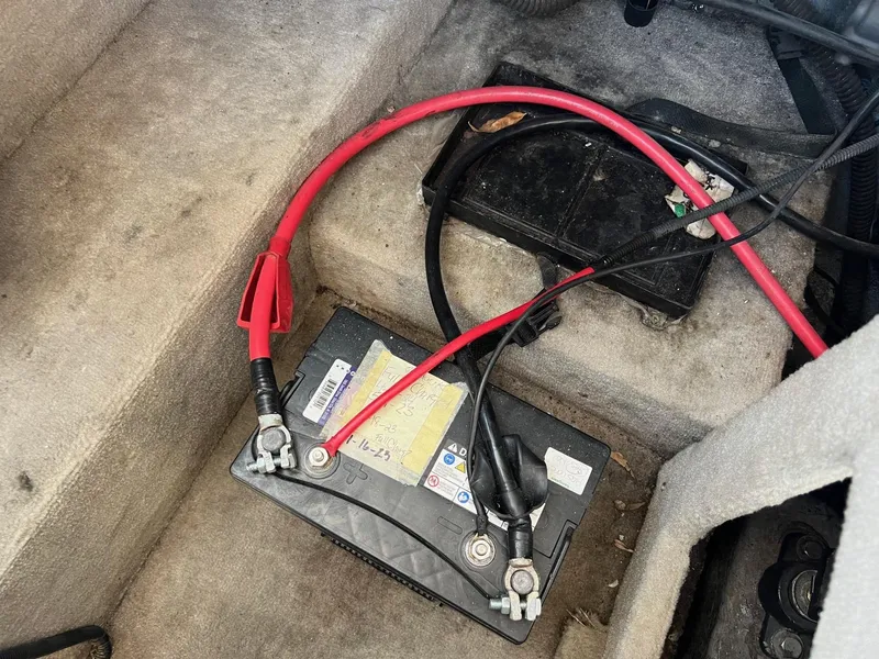 Slide: The Image of Battery with red and black cables in a 2001 Crownline 192 BR boat. - 17