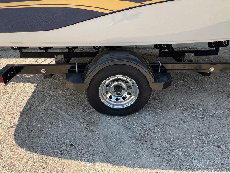 Slide: The Image of Trailer wheel of a 2001 Crownline 192 BR boat on gravel surface. - 19
