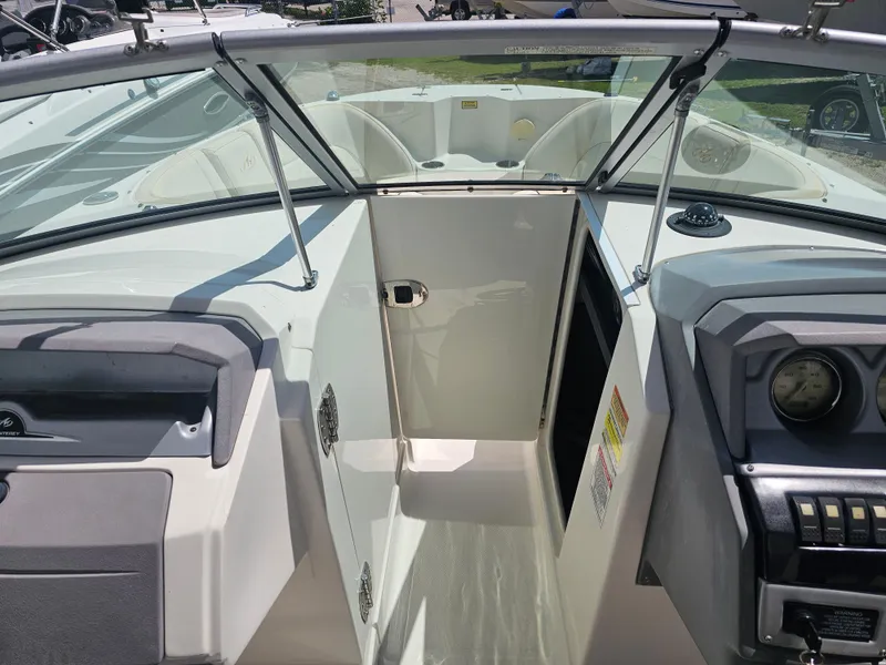 Slide: The Image of 2007 Monterey 220 EX boat interior with open cabin door and dashboard view. - 13