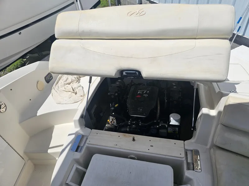 Slide: The Image of 2007 Monterey 220 EX boat engine compartment with open hatch, revealing engine details. - 14