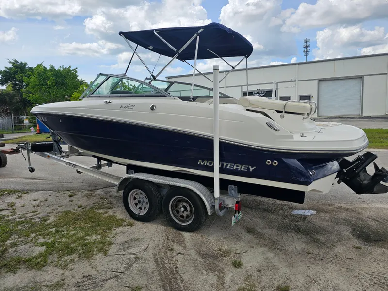 Slide: The Image of 2007 Monterey 220 EX boat on trailer, blue and white, with canopy, parked outdoors. - 4