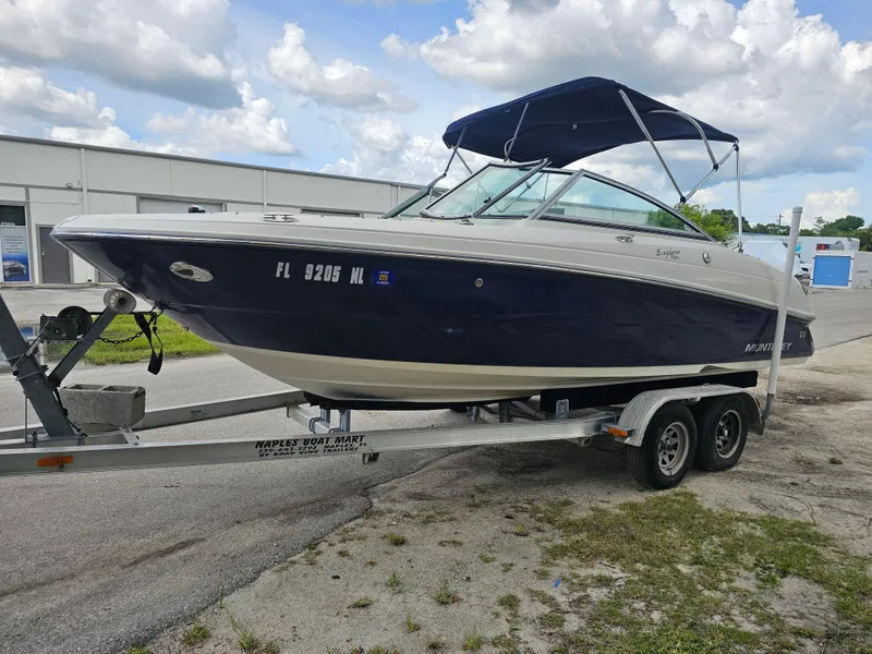 Slide: The Image of 2007 Monterey 220 EX boat on trailer, parked outdoors under cloudy sky. - 5