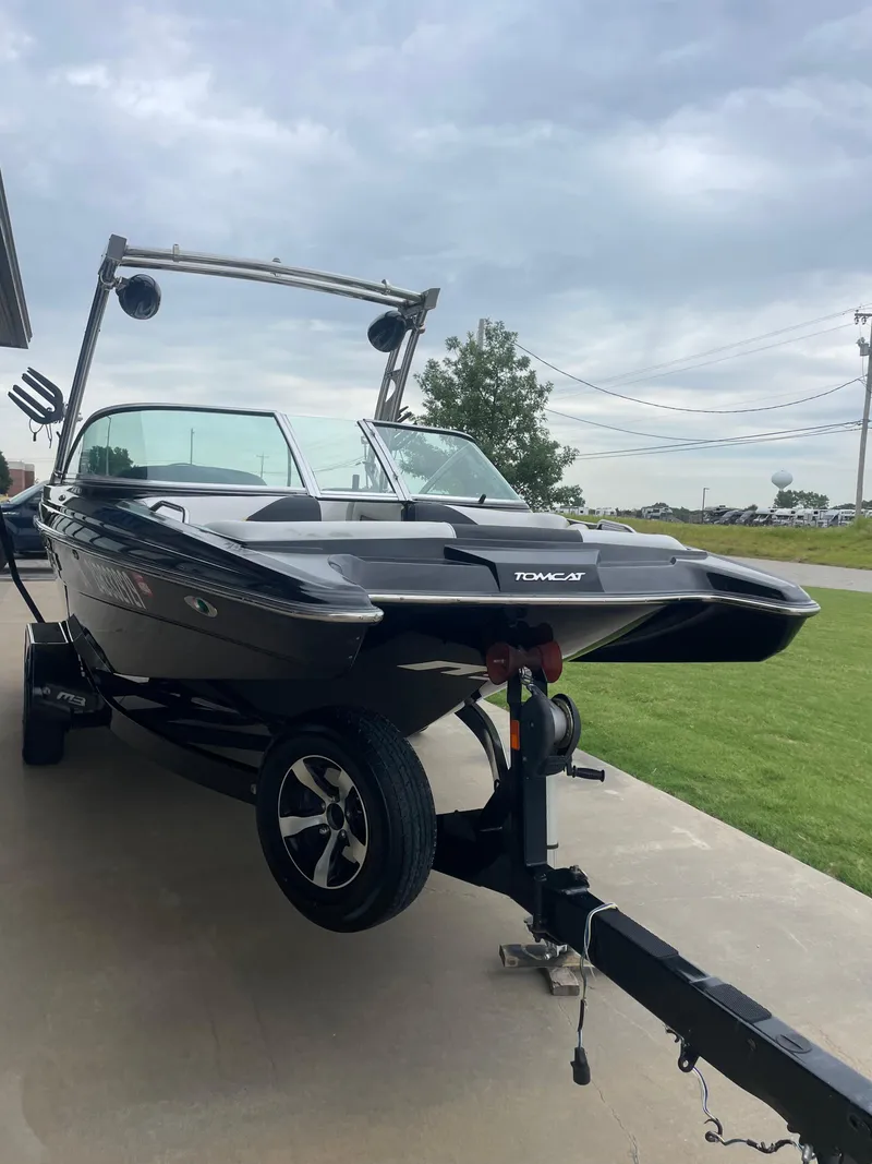 Slide: The Image of 2013 MB F21 Tomcat boat on trailer, parked outdoors under cloudy sky. - 18
