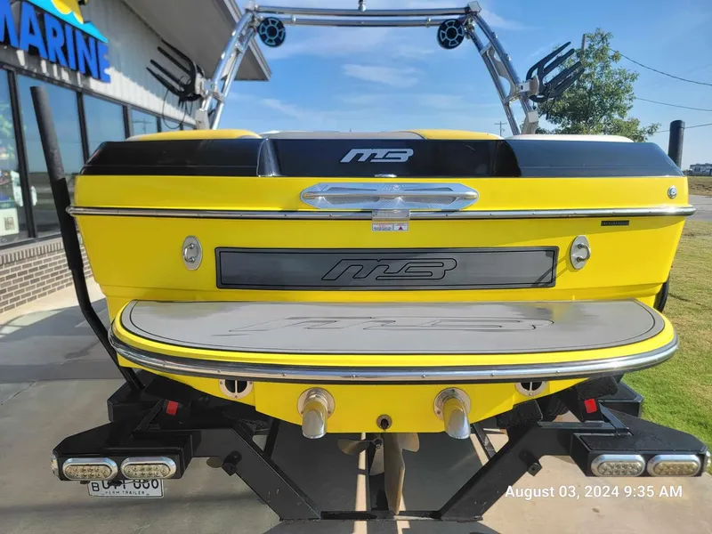 Slide: The Image of Yellow 2013 MB F21 Tomcat boat at a marine dealership, rear view. - 2