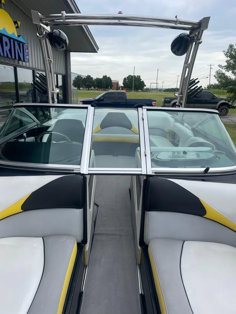 Slide: The Image of 2013 MB F21 Tomcat boat interior with yellow and black accents, parked near a building. - 20