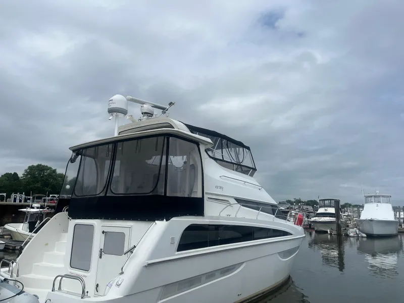 The Image of 2006 Carver 430 Cockpit Motor Yacht docked in a marina under cloudy skies. - 0