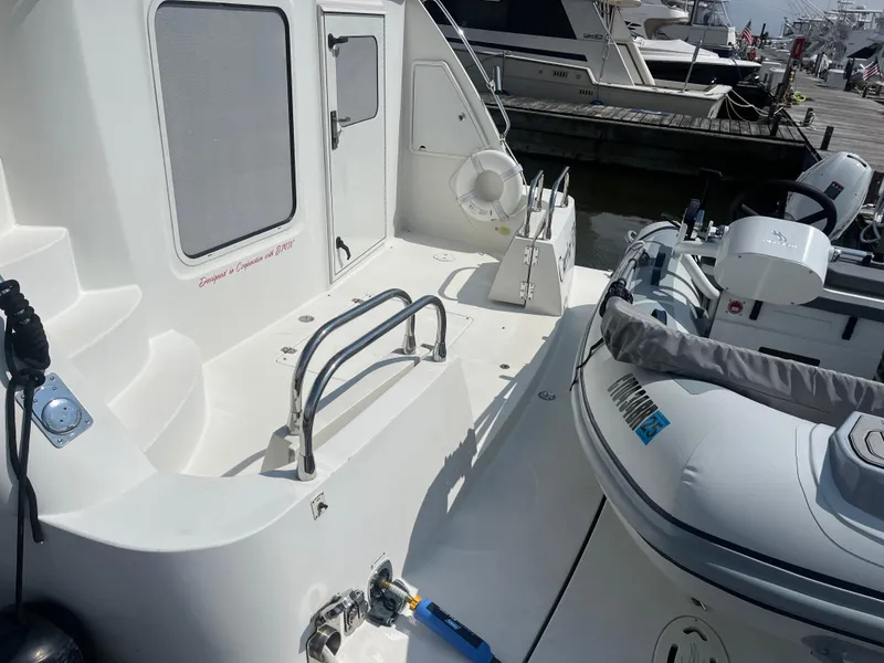 Slide: The Image of 2006 Carver 430 Cockpit Motor Yacht docked, featuring spacious deck and inflatable boat. - 13