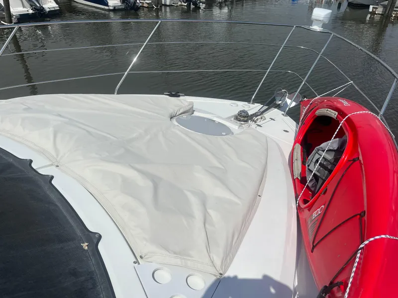 Slide: The Image of 2006 Carver 430 Cockpit Motor Yacht with red kayak on deck, docked at marina. - 14