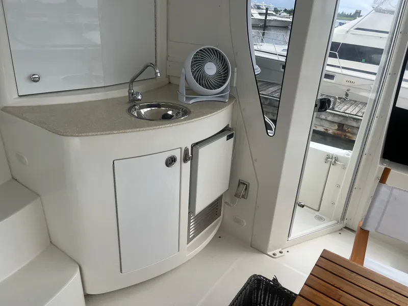 Slide: The Image of 2006 Carver 430 Cockpit Motor Yacht interior with sink, fan, and wooden table. - 17
