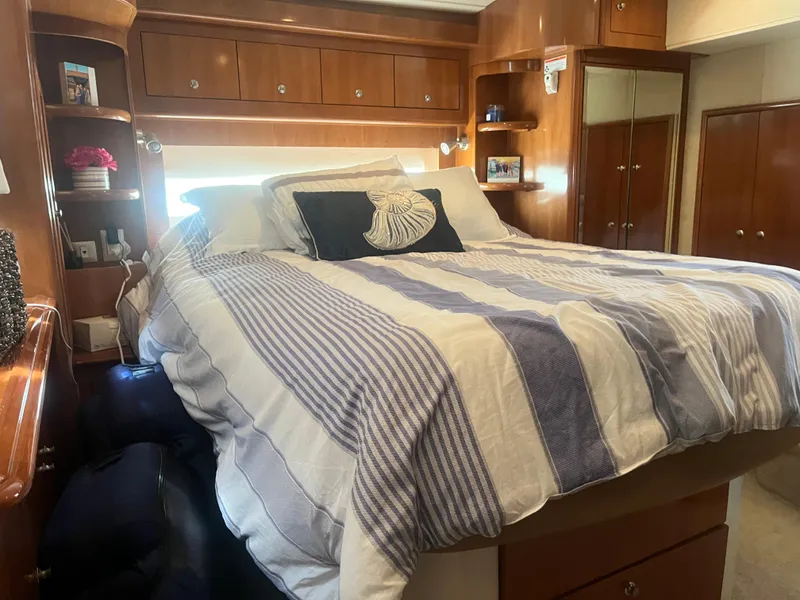 Slide: The Image of Luxurious bedroom interior of 2006 Carver 430 Cockpit Motor Yacht with striped bedding. - 36