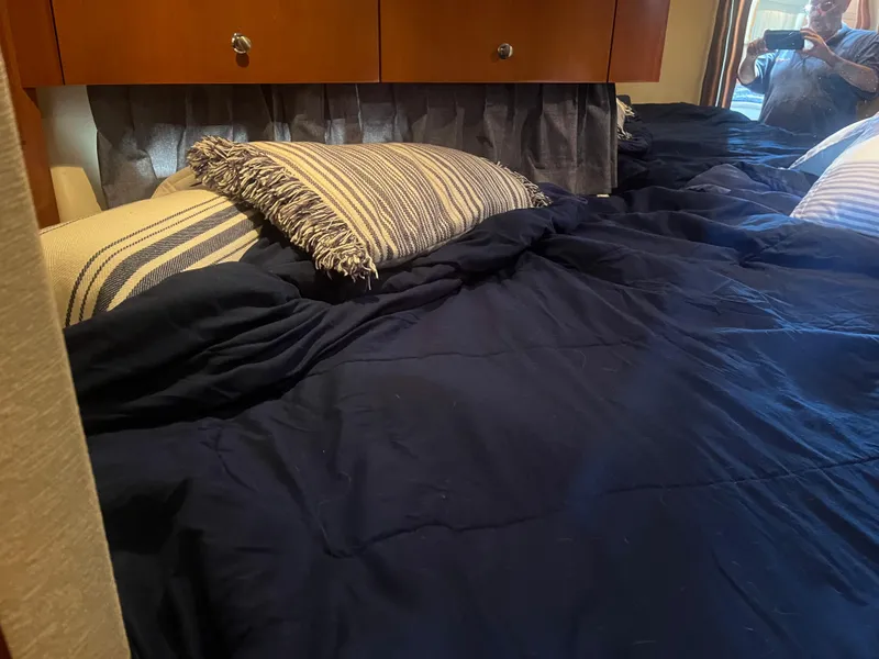Slide: The Image of Cozy bedroom in 2006 Carver 430 Cockpit Motor Yacht with striped pillows and navy bedding. - 41