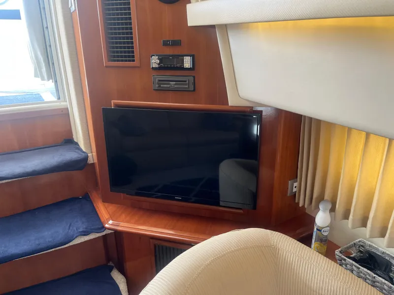 Slide: The Image of Interior of 2006 Carver 430 Cockpit Motor Yacht with TV and wooden paneling. - 43