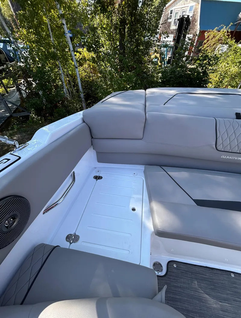Slide: The Image of 2024 Glastron GX 215 boat interior with gray seating and speaker. - 12