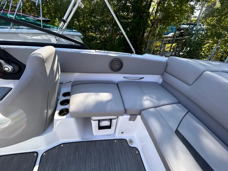 Slide: The Image of 2024 Glastron GX 215 boat interior with gray seating and cup holders. - 14