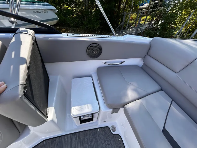 Slide: The Image of 2024 Glastron GX 215 boat interior with gray seating and speaker detail. - 15