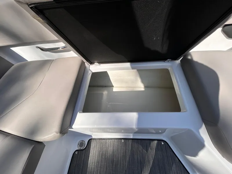 Slide: The Image of 2024 Glastron GX 215 boat storage compartment with open lid, showcasing spacious interior. - 24