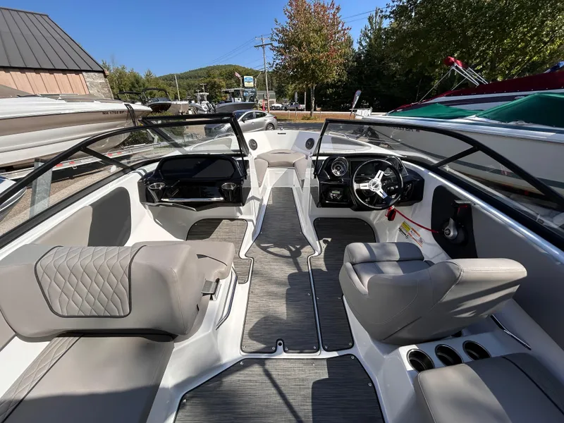 Slide: The Image of 2024 Glastron GX 215 boat interior with modern seating and dashboard design. - 27