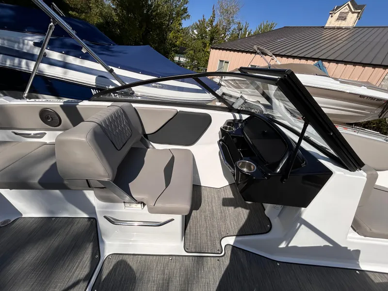 Slide: The Image of 2024 Glastron GX 215 boat interior with gray seating and sleek dashboard design. - 28