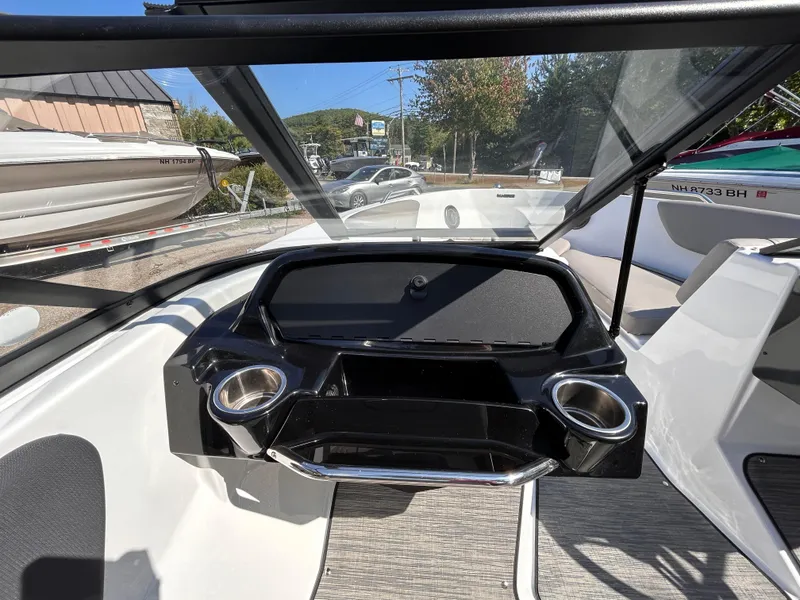 Slide: The Image of 2024 Glastron GX 215 boat dashboard with modern design and dual cup holders. - 29
