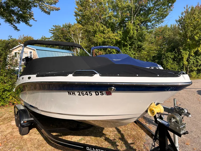 Slide: The Image of 2024 Glastron GX 215 boat on trailer, covered, parked outdoors. - 3