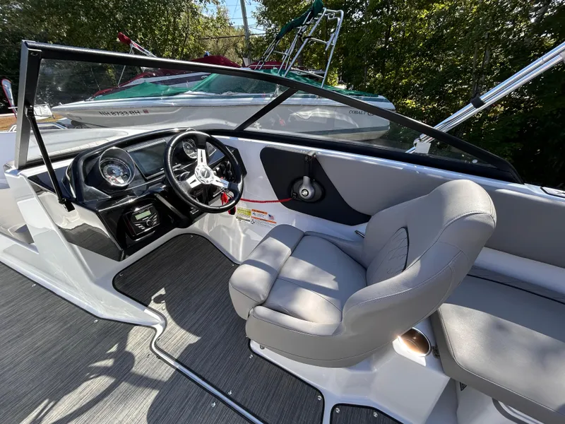 Slide: The Image of 2024 Glastron GX 215 boat interior with steering wheel and seating. - 32
