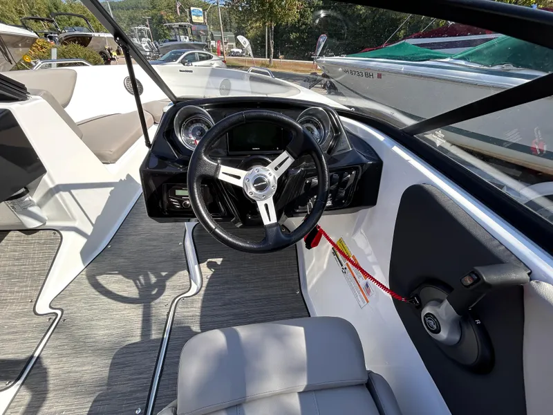 Slide: The Image of 2024 Glastron GX 215 boat interior with steering wheel and dashboard. - 33