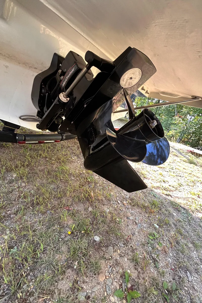 Slide: The Image of 2024 Glastron GX 215 boat propeller and stern drive on grassy ground. - 7