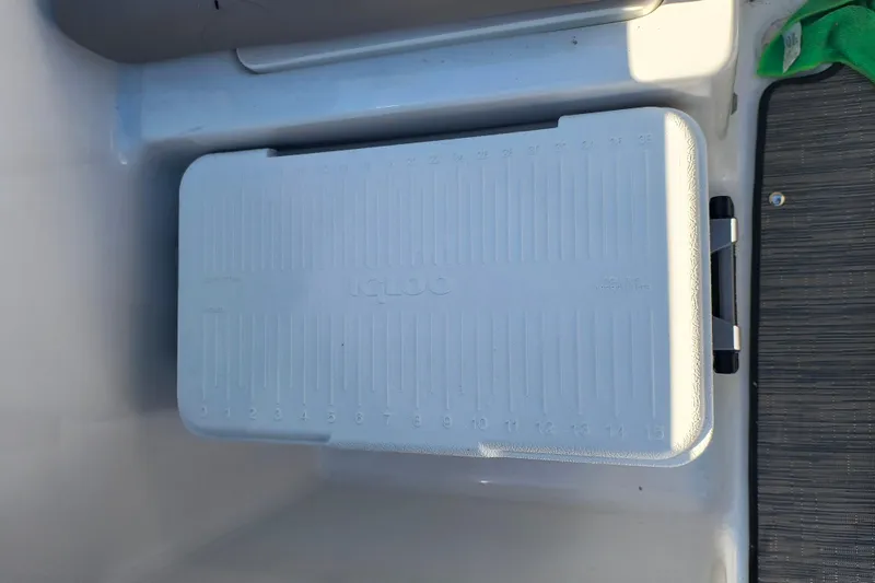 Slide: The Image of White Igloo cooler inside 2024 Glastron GX 215 boat compartment. - 17
