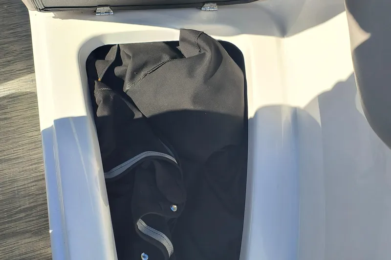Slide: The Image of Storage compartment in 2024 Glastron GX 215 boat with black fabric inside. - 19