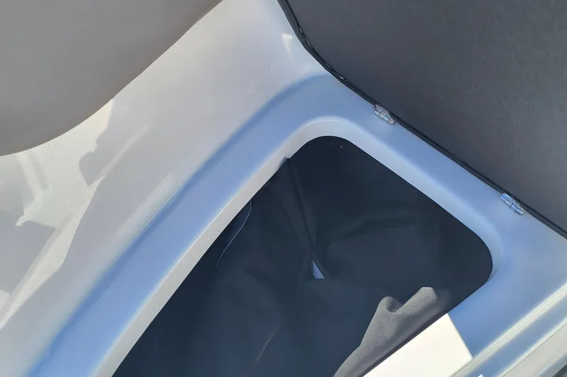 Slide: The Image of 2024 Glastron GX 215 storage compartment with open lid, showcasing interior space. - 20