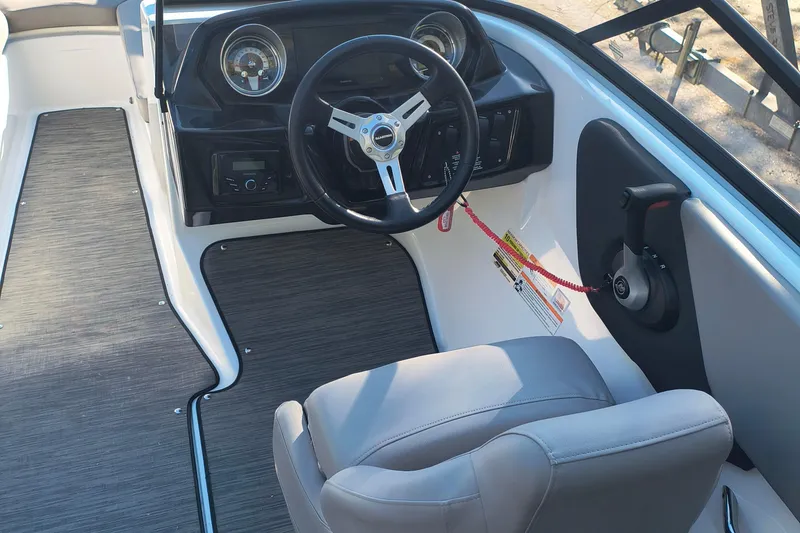 Slide: The Image of 2024 Glastron GX 215 boat cockpit with steering wheel and control panel. - 7