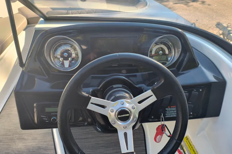 Slide: The Image of 2024 Glastron GX 215 dashboard with steering wheel and gauges. - 9