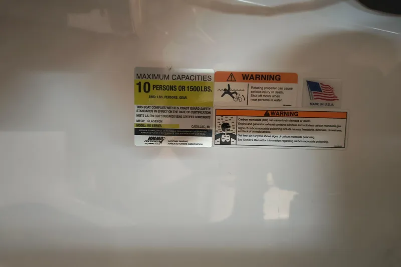 Slide: The Image of 2024 Glastron GX 215 capacity and safety warning labels, made in USA. - 13