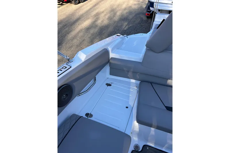 Slide: The Image of 2024 Glastron GX 215 boat interior with gray seating and speaker detail. - 18