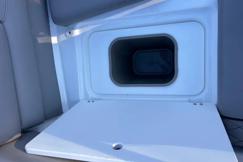 Slide: The Image of 2024 Glastron GX 215 boat storage compartment with open lid. - 21