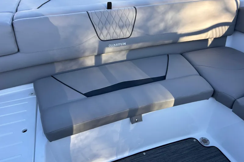 Slide: The Image of 2024 Glastron GX 215 boat interior with sleek gray seating and modern design. - 22
