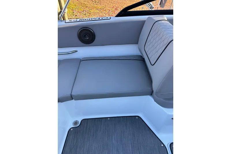 Slide: The Image of 2024 Glastron GX 215 boat interior with gray cushioned seating and speaker. - 27